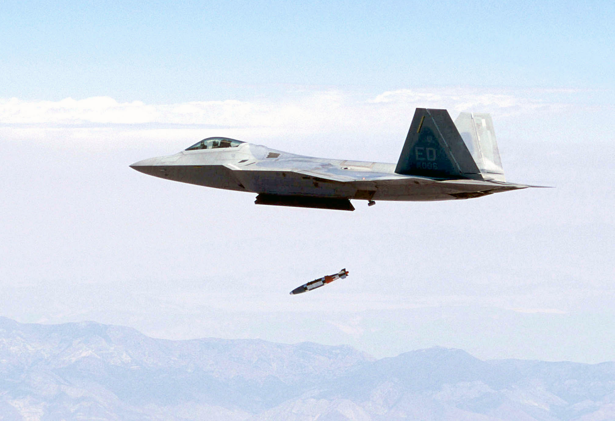 US Air Force (USAF) test pilot USAF Major (MAJ) John Teichert, releases a guided bomb unit (GBU)-32 1,000-lbs joint direct attack munitions (JDAM) from a USAF F/A-22A Raptor fighter at supersonic speed for the first time near California's Panamint Mountain range.